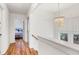 Bright hallway with hardwood floors, leading to a bedroom, with an elegant chandelier at 783 Lake Frances Dr, Charleston, SC 29412