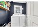 Laundry room with a front loading washer and dryer, wooden shelves, and a window at 783 Lake Frances Dr, Charleston, SC 29412