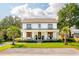 Beautifully landscaped two-story home with a charming front porch, lush green lawn, and symmetrical palm trees at 916 Kincade Dr, Mount Pleasant, SC 29464
