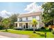 Picturesque two-story home with a lovely front porch, well-manicured lawn, and mature palm trees at 916 Kincade Dr, Mount Pleasant, SC 29464