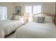 Bright bedroom with two beds, shuttered windows, and neutral tones creating a serene atmosphere at 10 Toms Turnaround Cir, Edisto Island, SC 29438