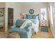 Bright bedroom with wood floors, beachy accents, a comfortable chair, and an ensuite bathroom offers a relaxing retreat at 10 Toms Turnaround Cir, Edisto Island, SC 29438