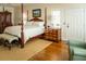 Spacious bedroom with a four-poster bed, hardwood floors, and a sunny window at 10 Toms Turnaround Cir, Edisto Island, SC 29438
