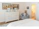 Well-decorated bedroom with dresser, paintings, and a chair next to the ensuite bathroom at 10 Toms Turnaround Cir, Edisto Island, SC 29438