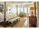 Well-lit bedroom featuring a luxurious bed, hardwood floors, and multiple windows at 10 Toms Turnaround Cir, Edisto Island, SC 29438