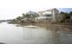 Exterior view of waterfront homes with palm trees reflecting in the water at 10 Toms Turnaround Cir, Edisto Island, SC 29438