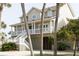 Inviting home boasts a large porch, perfect for relaxing and enjoying the coastal breeze at 10 Toms Turnaround Cir, Edisto Island, SC 29438