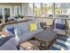 Relaxing screened porch features wicker furniture, blue and white striped rug, and views of palm trees at 10 Toms Turnaround Cir, Edisto Island, SC 29438