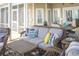 Relaxing screened porch features wicker furniture, modern patterned cushions, and views of trees at 10 Toms Turnaround Cir, Edisto Island, SC 29438
