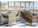 Comfortable screened porch with wicker furniture, ocean views, and blue striped rug at 10 Toms Turnaround Cir, Edisto Island, SC 29438