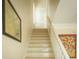 Bright staircase with neutral walls, framed art, and access to a hallway door provides inviting transition between levels at 10 Toms Turnaround Cir, Edisto Island, SC 29438