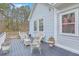 Back deck with white wicker seating and plants overlooking the backyard and tall trees at 1012 Denali Ct, Summerville, SC 29483