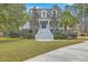 Charming two-story home with a welcoming front porch, lush landscaping, and a well-manicured lawn and long stairway at 1012 Denali Ct, Summerville, SC 29483