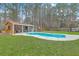 Backyard kidney-shaped pool featuring a concrete surround and a cabana surrounded by a tall, mature tree line at 1012 Denali Ct, Summerville, SC 29483