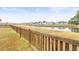 Spacious backyard with a wooden fence bordering a scenic pond and neighboring houses at 106 Terrapin Cir, Summerville, SC 29483