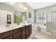 A bathroom with double vanities, large mirror, a standalone tub, tiled floors, and a separate shower at 106 Terrapin Cir, Summerville, SC 29483