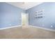 A simple bedroom with blue walls, a door leading to another room, and shelves on the wall at 106 Terrapin Cir, Summerville, SC 29483
