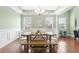 Bright dining room features a chandelier, wood floors, and a rustic wooden dining table with white chairs at 106 Terrapin Cir, Summerville, SC 29483