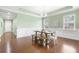 Elegant dining room with a white wainscoting, wood floors, and a rustic wooden table and white chairs at 106 Terrapin Cir, Summerville, SC 29483