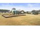 Community playground featuring a slide, climbing bars, and benches surrounded by a black fence and open lawn at 106 Terrapin Cir, Summerville, SC 29483