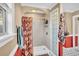 Bathroom featuring a shower with decorative curtain, glass block partition, and red accent wall at 1060 Oakcrest Drive, Charleston, SC 29412