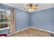 Cozy bedroom with hardwood-style floors, blue walls, and a bright window for natural light at 1060 Oakcrest Drive, Charleston, SC 29412