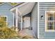 Close-up of the home's entry featuring a covered porch with white trim and a white front door at 1060 Oakcrest Drive, Charleston, SC 29412