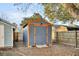 Backyard storage shed with orange trim on a gravel lot with grass at 1060 Oakcrest Drive, Charleston, SC 29412