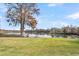 Backyard view with waterfront access, featuring a wooden pier, lake and Adirondack chairs at 1106 Mccrae Dr, Moncks Corner, SC 29461