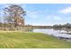 Backyard view with waterfront access, featuring a wooden pier, lake and Adirondack chairs at 1106 Mccrae Dr, Moncks Corner, SC 29461