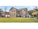 Back exterior view of a two-story brick home with large windows, a spacious yard, and a serene backdrop at 1106 Mccrae Dr, Moncks Corner, SC 29461