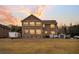 Back exterior view of a two-story brick home with large windows, a spacious yard, and a serene backdrop at 1106 Mccrae Dr, Moncks Corner, SC 29461