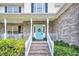 Charming front porch with brick steps, a bright blue door, and decorative wreath and colorful landscaping at 1106 Mccrae Dr, Moncks Corner, SC 29461
