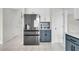 Modern kitchen features stainless steel appliances, tile floors, and stylish blue and white cabinetry at 1106 Mccrae Dr, Moncks Corner, SC 29461