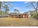 A beautiful backyard with a brick home, wooden deck, mature trees, and ample space at 120 Carol Dr, Goose Creek, SC 29445