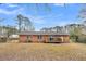 A brick home featuring a wooden deck and spacious backyard with trees at 120 Carol Dr, Goose Creek, SC 29445