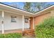 Charming front porch with brick steps and a white door, surrounded by lush green shrubbery and siding at 120 Carol Dr, Goose Creek, SC 29445