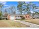 Inviting single-story brick home with a driveway and lush landscaping surrounded by mature trees at 120 Carol Dr, Goose Creek, SC 29445