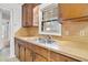 Kitchen sink with double basin, wood cabinets, and natural light from the window create a bright and functional space at 120 Carol Dr, Goose Creek, SC 29445