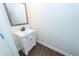 Bathroom vanity with a white cabinet, mirror, dark faucet, and dark wood floors at 123 White Picket Ln, Summerville, SC 29483