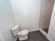 Bathroom featuring dark wood floors, toilet, and a walk-in shower with marble-look tile at 123 White Picket Ln, Summerville, SC 29483
