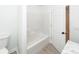 This bathroom features a white bathtub with a shower and a white door at 123 White Picket Ln, Summerville, SC 29483
