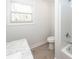 This bathroom features a marble countertop, a window with blinds, and a bathtub with a shower at 123 White Picket Ln, Summerville, SC 29483