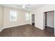 Bedroom with two windows, ceiling fan, wood floors, and an open door to the bathroom at 123 White Picket Ln, Summerville, SC 29483