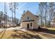 Exterior view of house with concrete driveway and surrounded by tall pine trees at 123 White Picket Ln, Summerville, SC 29483