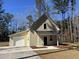 Charming beige two-story home with a single car garage, black roof, and a well-maintained front yard at 123 White Picket Ln, Summerville, SC 29483