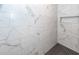 Modern bathroom shower featuring marble-patterned walls and a tiled floor at 123 White Picket Ln, Summerville, SC 29483