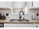Close-up of a kitchen sink with granite countertops, white cabinetry, and a window for natural light at 129 Isherwood Dr, Goose Creek, SC 29445