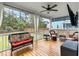 Covered porch with comfortable seating, a TV, and ceiling fan overlooking the landscaped yard at 1502 Checker Ct, Mount Pleasant, SC 29466