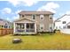 Landscaped backyard with green grass, fire pit, flower beds, and a screened-in porch at 1502 Checker Ct, Mount Pleasant, SC 29466